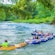 A group of people float in rafts down a river surrounded by jungle